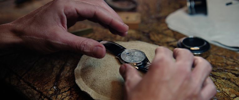Close-up of a watchmaker replacing a watch battery, showing professional watch repair.